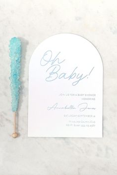 a blue toothbrush sitting on top of a white table next to a card that says oh baby