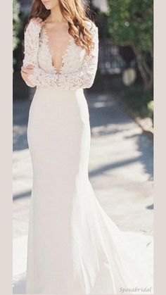 a woman in a white wedding dress is standing on the sidewalk with her hand on her hip