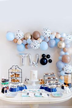 a table topped with lots of balloons and confetti