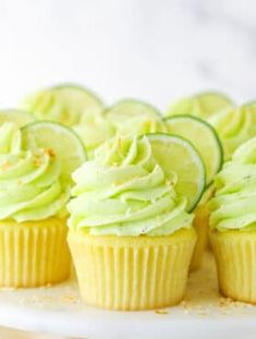 cupcakes with cucumber and lime frosting on a white cake plate