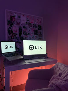 two laptop computers sitting on top of a desk next to a purple chair in a room