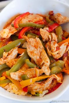 a white bowl filled with chicken and veggies