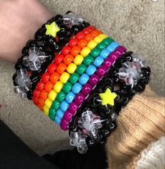 a person's arm with bracelets made out of plastic beads and star charms