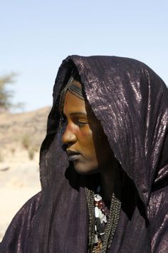 a woman wearing a purple shawl in the desert