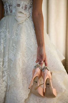 the bride is holding her wedding shoes