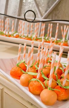 carrots and candies are arranged in rows on a white platter with candles