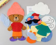 two teddy bears are next to some cut out felt pieces with clothes and sunglasses on them