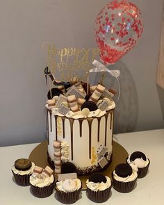 a birthday cake and cupcakes on a table