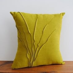 a green pillow sitting on top of a wooden table