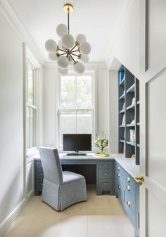 a chair sits in front of a desk with a computer and bookshelf on it