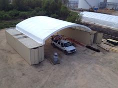 a white van parked in front of a building under a cover over it's roof