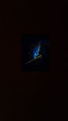 a person holding a baseball bat in the dark with a blurry image behind them