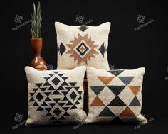 three decorative pillows and a vase on a black background with the same pattern in different colors