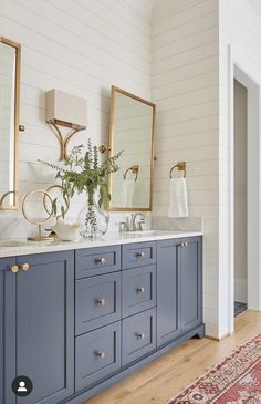 a bathroom with blue cabinets and gold accents