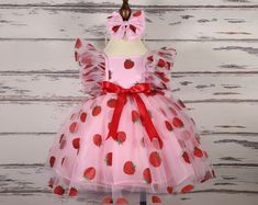 ### Product Description Our enchanting Strawberry Pattern Dress for children, crafted from luxurious tulle, satin, and organza, and adorned with delicate pearls. This knee-length dress is perfect for making your little one feel like a princess. The full set includes a beautifully designed dress, a matching headband, and a pair of red shoes.  This dress is ideal for various special occasions, including: - Birthday parties - Family gatherings - Weddings - Holiday celebrations - Photo shoots - Scho Berry First Birthday Dress, Pink Tulle Tutu Dress For Christmas, Red Princess Dress For Summer Party, Pink Ruffled Tutu Dress For Christmas, Cute Pink Tutu Dress For Christmas, Pink Ruffled Christmas Tutu Dress, Red Tutu Dress For Spring Wedding, Pink Christmas Tutu Dress With Ruffles, Christmas Pink Ruffled Tutu Dress