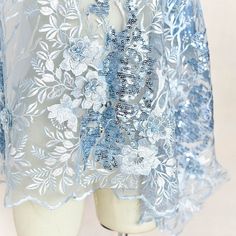 a white mannequin with blue lace and flowers on it