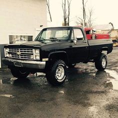 a black pickup truck parked in front of a building