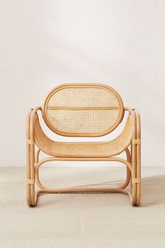 a chair made out of bamboo and wicker with a white wall in the background