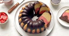 a bundt cake on a white plate with raspberries and other desserts