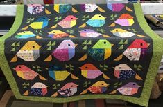 a quilted table runner with colorful birds on it