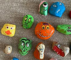 several painted rocks with faces on them sitting on the ground in front of each other