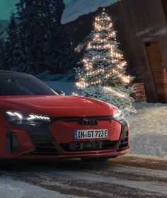 a red car parked in front of a christmas tree