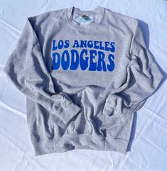 the los angeles dodgers sweatshirt is laying on a white sheet