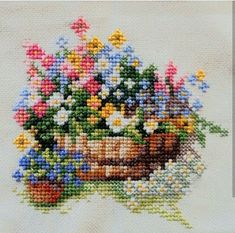 a cross stitch picture of flowers in a basket