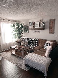 a living room with couches, coffee table and pictures on the wall above it