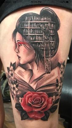 a woman with a book and rose tattoo on her thigh