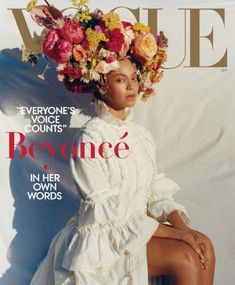 a woman sitting on top of a magazine cover wearing a dress and flowers in her hair