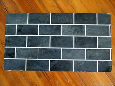 a black and white brick wall laying on top of a wooden floor