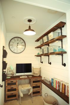 a home office area with shelves, desk and clock on the wall above it's desk