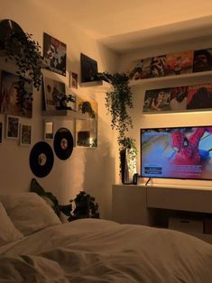 a bedroom with pictures on the wall and a bed in front of a flat screen tv