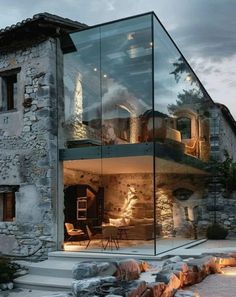 the glass house is surrounded by rocks and stone, with stairs leading up to it