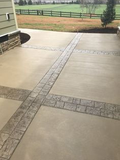 an outdoor patio with concrete pavers and brick edging on the side of it