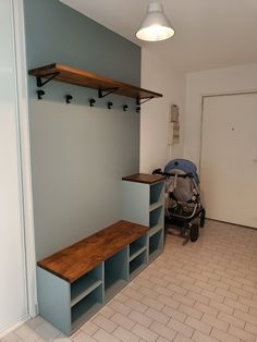 there is a baby carriage in the room with shelves on the wall and a stroller behind it