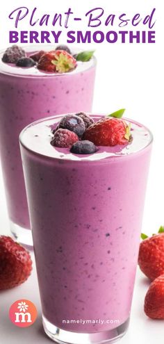 two glasses filled with berry smoothie next to strawberries