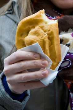 a woman holding up a half eaten doughnut