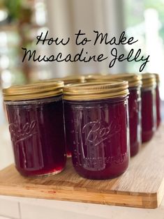 four jars of homemade muscadine jelly sitting on a cutting board with the words how to make muscadine jelly