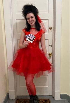 a woman in a red dress is holding a photo