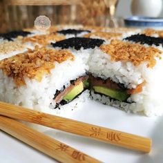 a plate with some sushi and chopsticks on it