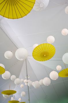 many white and yellow umbrellas hanging from the ceiling