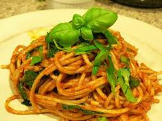 a plate of spaghetti with basil on top