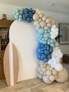 the balloon arch is decorated with blue, white and grey balloons in an elegant manner