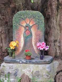 there are flowers and vases in front of a statue