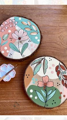 two wooden coasters with flowers painted on them