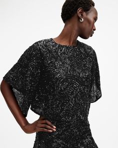 Sparkle all season long. The Ivy Top has a flowing shape that boasts a round neck and delicately draped sleeves. It's relaxed-fitting and cropped to create an elevated structure. Elegant gems, sequins and bead embellishments are a luxe touch. Dress this up with the matching skirt or fitted pants (don't forget a statement metallic heel, now that's a look).  This top is designed to a relaxed fit Keyhole button closure at the back of the neck Round neck Short sleeves Cropped Draped sleeves and heml Elegant Batwing Sleeve Party Tops, Elegant Cropped Sequin Top, Chic Crew Neck Blouse For Evening, Black Ivy, Embellished Crop Top, Drape Sleeves, The Ivy, Chunky Knitwear, Embellished Top