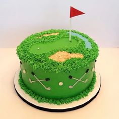 a green cake with a golf hole and flag on the top is ready to be eaten