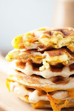 a stack of pancakes topped with eggs and bacon